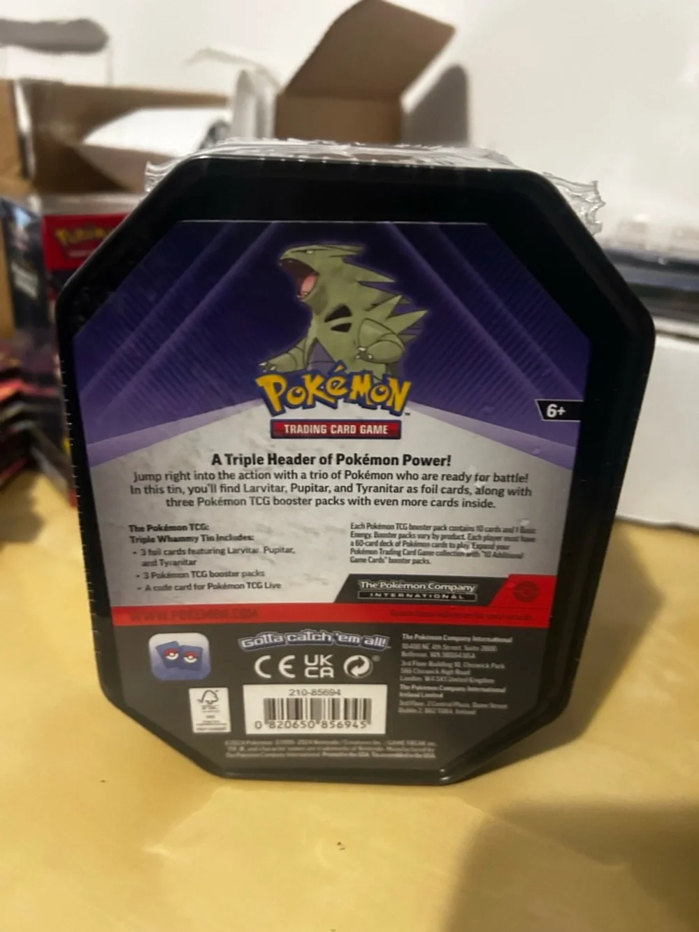 Pokemon Tin Featuring Green Tyranitar on Blue and Purple Artwork